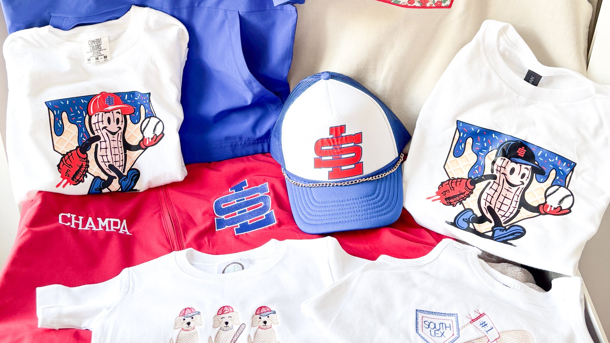 Collection of branded clothing and accessories including jackets, hats, and t-shirts on a neutral background.